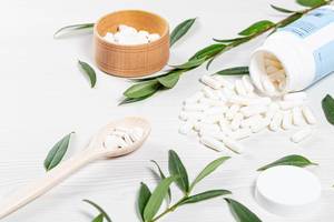 Medical-preparations-in-capsules-and-tablets-scattered-on-a-white-wooden-background.jpg