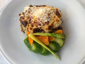 Mediterranes Mittagessen: Griechisches Gericht Moussaka aus Hackfleisch, mit Käse, Karotten und grünem Spargel