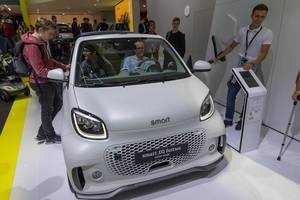 Menschen sitzen im Ausstellungsfahrzeug und testen Elektromobilität von Smart: EQ fortwo Elektroauto
