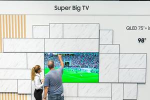 Menschen stehen vor dem Super Big TV QLED 75" von Samsung