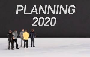 Menschenfiguren stehen vor einer Wand mit  "Planning 2020" als Text