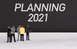 Menschenfiguren stehen vor einer Wand mit  "Planning 2021" als Text