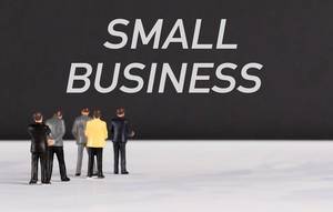 Menschenfiguren stehen vor einer Wand mit  "Small Business" als Text