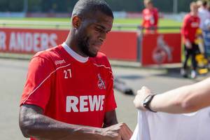 Middle striker Anthony Modeste signs autograph on fan shirts after soccer training in Cologne