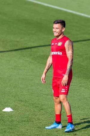 Midfielder Charles Aránguiz, with religious tattoos, laughs cheerfully during training on the football field
