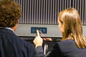 Miele Backofen Generation 7000 mit Tastecontrol: Frau wählt auf dem Touchscreen das Autoprogramm aus