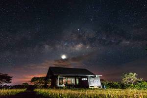 Milchstraße bei klarem Sternehimmel über in Natur stehendem Ferienjhaus in Don Salvador, Philippinen