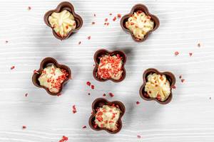 Milk chocolates with cream and strawberry slices. Top view (Flip 2019)
