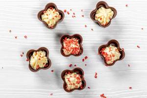 Milk chocolates with cream and strawberry slices. Top view
