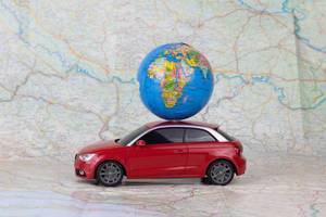 Miniature toy car carrying a small globe