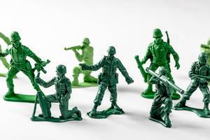 Miniature toy soldiers with guns on white background