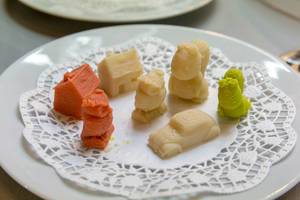 Mit 3D Drucksystem für Lebensmittel hergestellte, bunte Figuren auf weißem Tortenpapier
