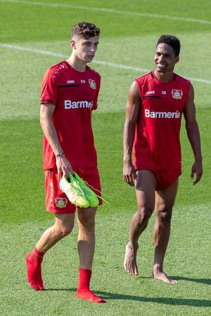 Mittelfeldspieler Kai Havertz und Fußballer Wendell ziehen nach dem Fußballtraining die Schuhe aus und gehen vom Platz