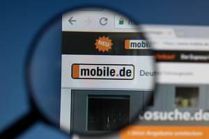 Mobile.de logo on a computer screen with a magnifying glass