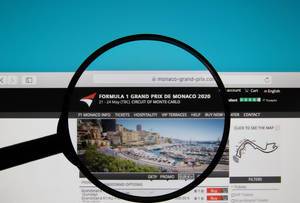 Monaco Grand Prix website on a computer screen with a magnifying glass