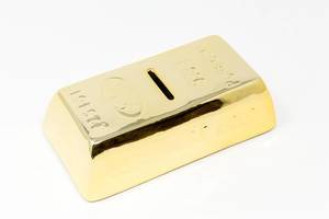 Money box in the form of gold bar in front of white background