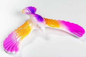 Nahaufnahme einer Spielzeugfigur: Farbiger Adler mit ausgebreiteten Flügeln