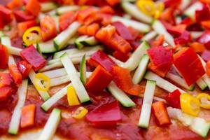 Nahaufnahme einer vegetarischen Pizza mit Zucchini und Paprika