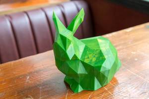 Nahaufnahme eines grünen Kaninchens auf einem Holztisch gedruckt von einem 3D Drucker