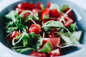 Nahaufnahme eines leichten Salats für den Sommer mit Tomaten und Rukola