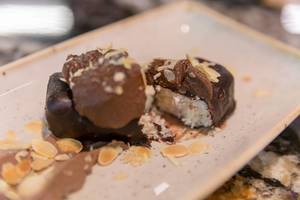 Nahaufnahme eines Nachtisches mit Kokos, Schokoladenguss und Mandelflocken im Fit Kitchen in Barcelona, Spanien