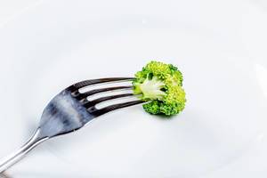 Nahaufnahme eines Stück Brokkoli auf einer Gabel aufgespießt