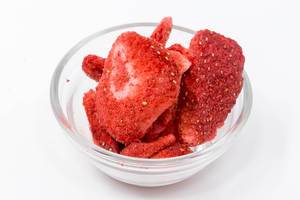 Nahaufnahme- Lio Bites - getrocknete Erdbeeren in Glasschale auf weißem Hintergrund