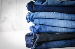 Nahaufnahme: Stapel von verschieden farbigen Jeans Hosen