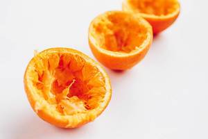 Nahaufnahme von ausgepressten Orangen vor weißem Hintergrund