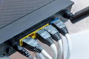 Nahaufnahme von einem modernen WIFi Router verbunden mit Kabeln