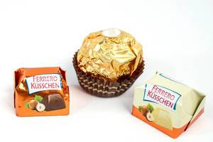 Nahaufnahme von Ferrero Küsschen mit Vollmilch und Weißer Schokolade und Ferrero Rocher vor weißem Hintergrund
