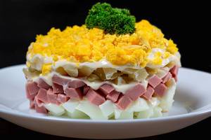 Nahaufnahme von frischem Salat aus Kartoffeln, Eiern, Schinken und Mayonnaise