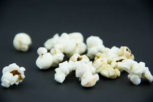 Nahaufnahme von gepopptem Popcorn auf schwarzem Hintergrund