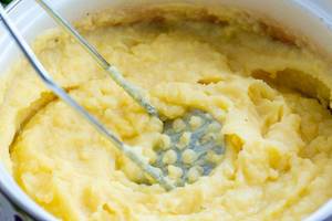 Nahaufnahme von gestampften Kartoffeln mit Butter für Kartoffelbrei in Pfanne