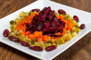 Nahaufnahme von gesundem, vegetarischem Salat aus Bohnen, Gewürzgurken, Karotten und Rote Bete