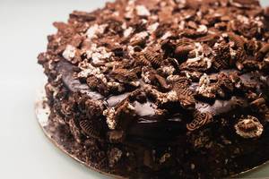 Nahaufnahme von leckerem Schokoladenkuchen mit Schokoglasur Oreo-Stücken