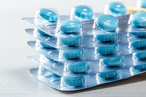 Nahaufnahme von Stapel Blister-Folie gefüllt mit runden blauen Tabletten