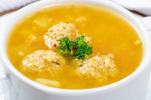 Nahaufnahme von Suppe mit Fleischbällchen und frischer Petersilie