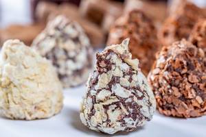 Nahaufnahme von Süßigkeiten in Pyramidenform aus weißer und dunkler Schokolade und Milch
