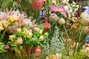 Nahaufnahme von Verkaufsauslage verschiedener bunter Blumen in Vasen