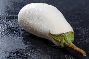 Nasse, frischgewaschen weiße Aubergine, auf schwarzer Oberfläche