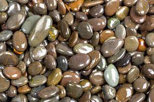 Naturally polished dark rock pebbles background