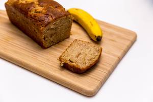 Neue Werte Banana bread close up on a wooden cutting board and white background