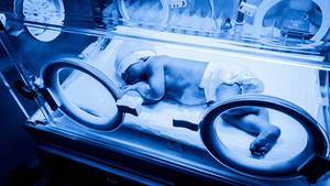 Newborn baby in an incubator machine receiving phototherapy for neonatal jaundice
