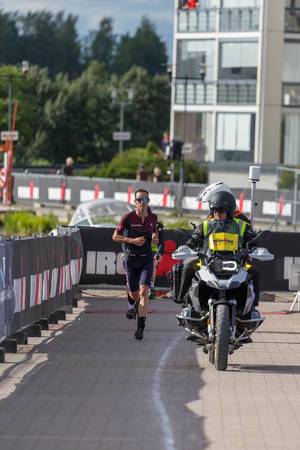 Nicholas Kastelein rennt den Marathon während des Ironman 70.3 - Triathlon in Lahti, Finnland, mit Motorradeskorte