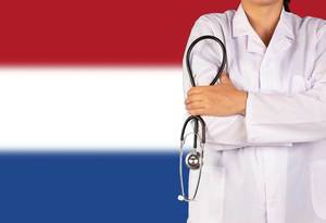 Niederländisches Gesundheitssystem symbolisiert durch die Nationalflagge und eine Ärztin mit Stethoskop in der Hand