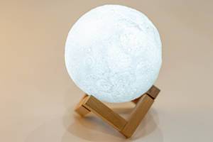 Night light in the form of a shining moon on a wooden stand (Flip 2019)