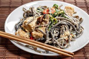 Noodles with cuttlefish ink in creamy sauce with tuna