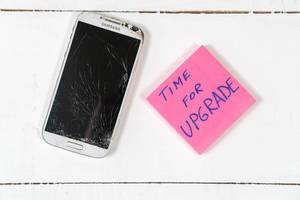 Notizzettel mit Text "Time For Upgrade" - Zeit für eine Verbesserung", neben einem kaputten Samsung-Handy