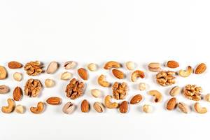 Nuts of different types on a white background with free space, top view
